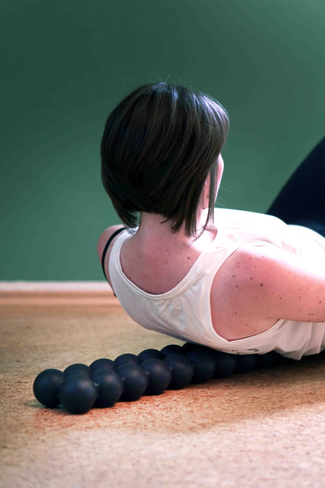 Übung mit der Faszienrolle im Liegen